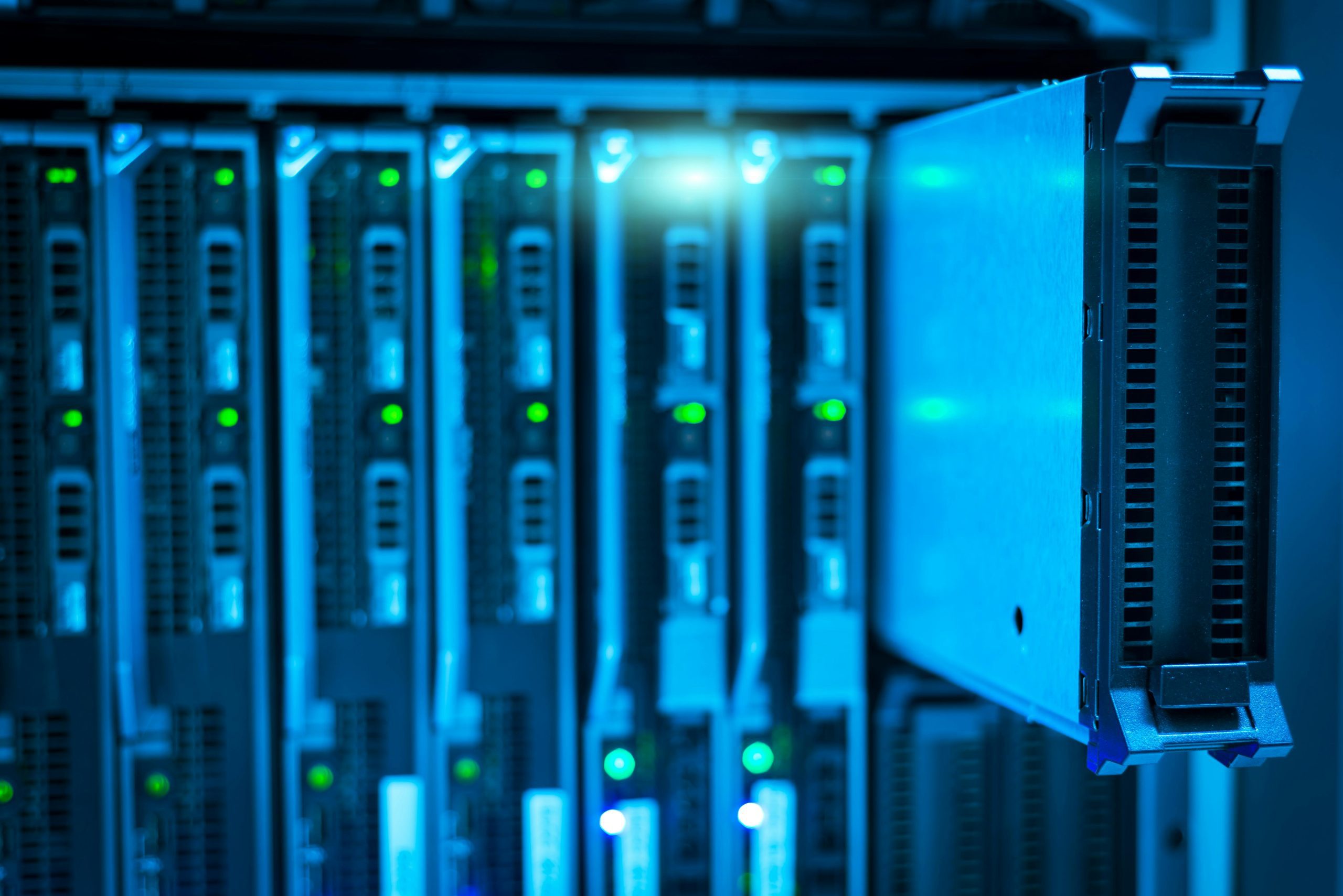 Imagen de servidores de datos con iluminación azul, representando el almacenamiento y la gestión de bases de datos.